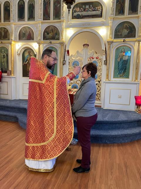 Fr. Joseph annointing the newly Chrismated in the front of the Church.