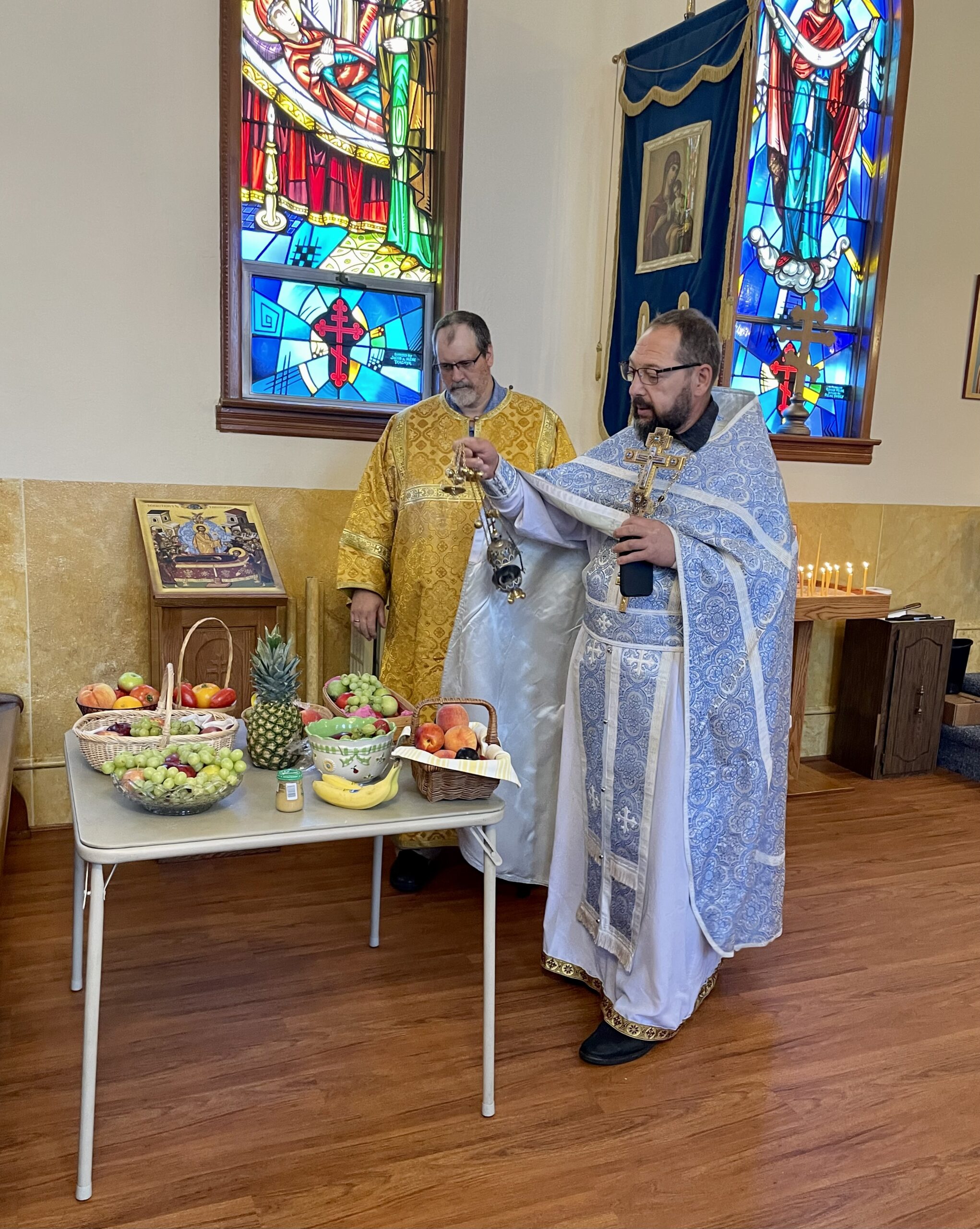 Orthodox priest blesses a table of fruit on the feast of the Transfiguration